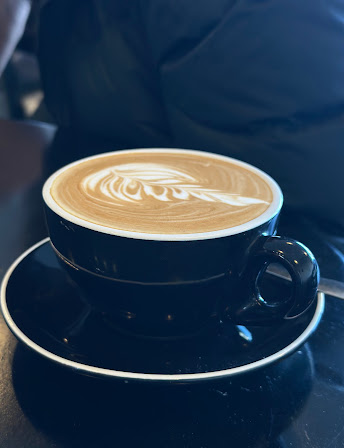 Flat white served in a black cup