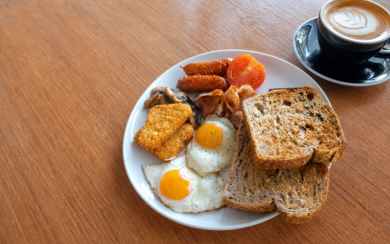 NZ Café big breakfast with eggs, toast, hash browns, sausages and flat white